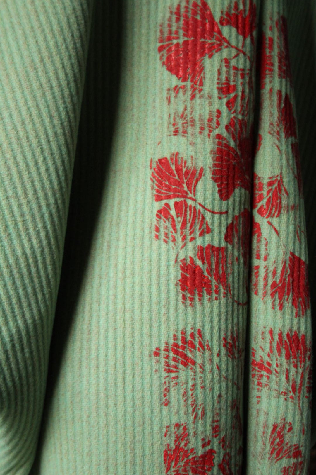 dettaglio di un tessuto dipinto a mano da donatella, fiori rossi su tessuto verde